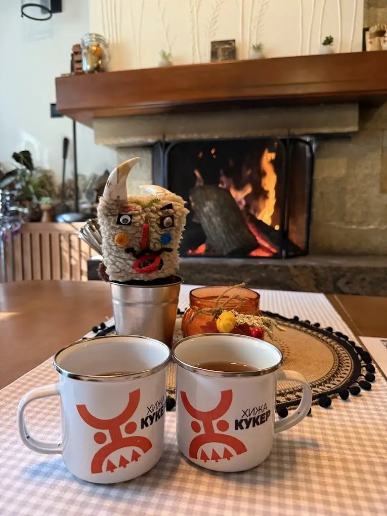 Две чаши чай с кукера на хижата пред запалената камина